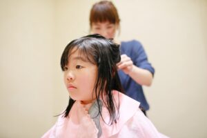 髪を切ってもらっている子供