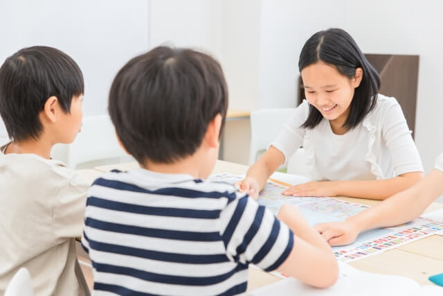 学校の教室でグループ学習する女の子